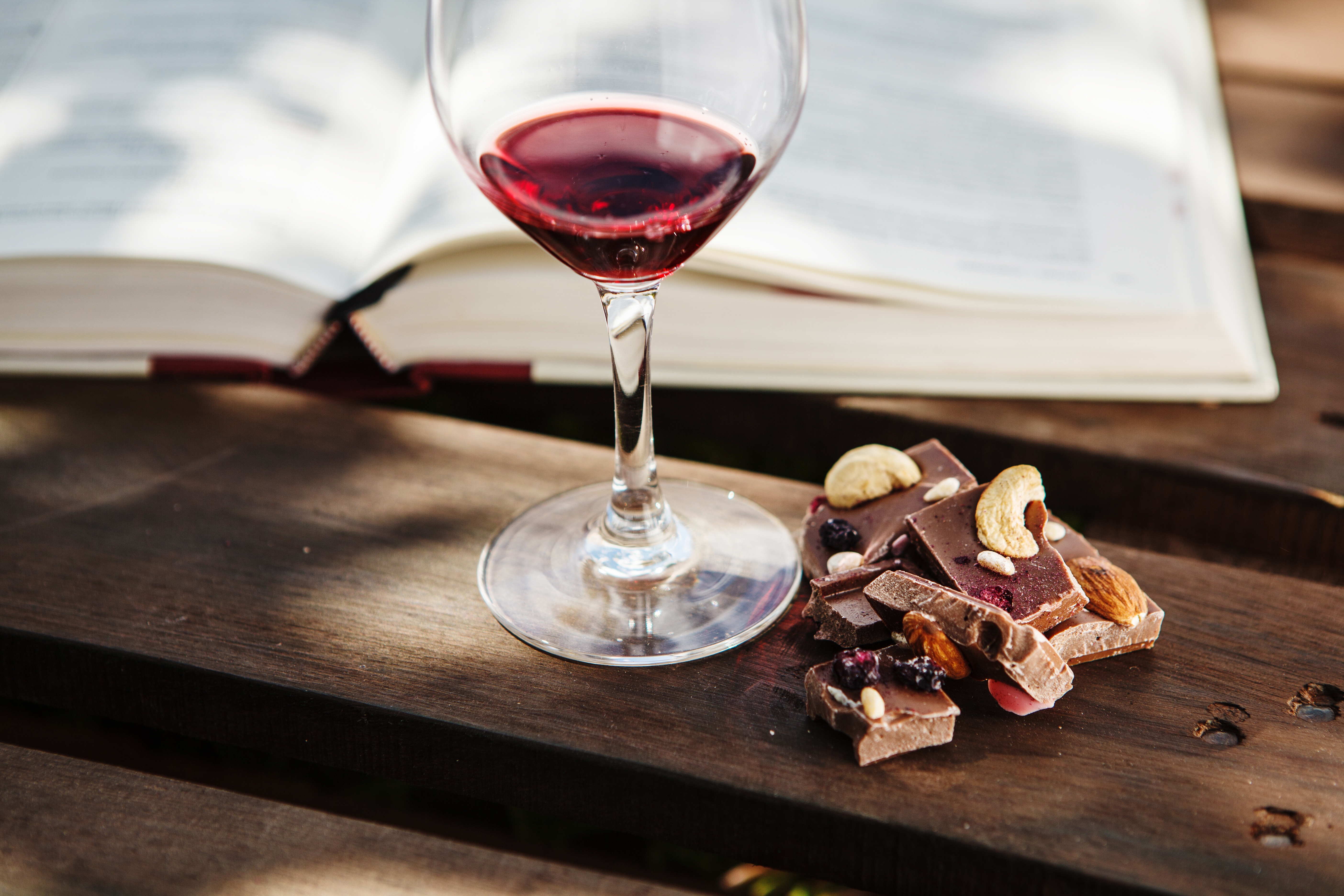 A glass of red wine with pieces of delicious-looking chocolate