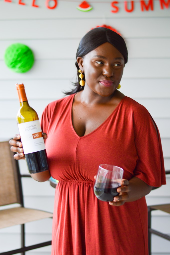 Woman smiling and welcoming summer with Cameron Hughes red wine