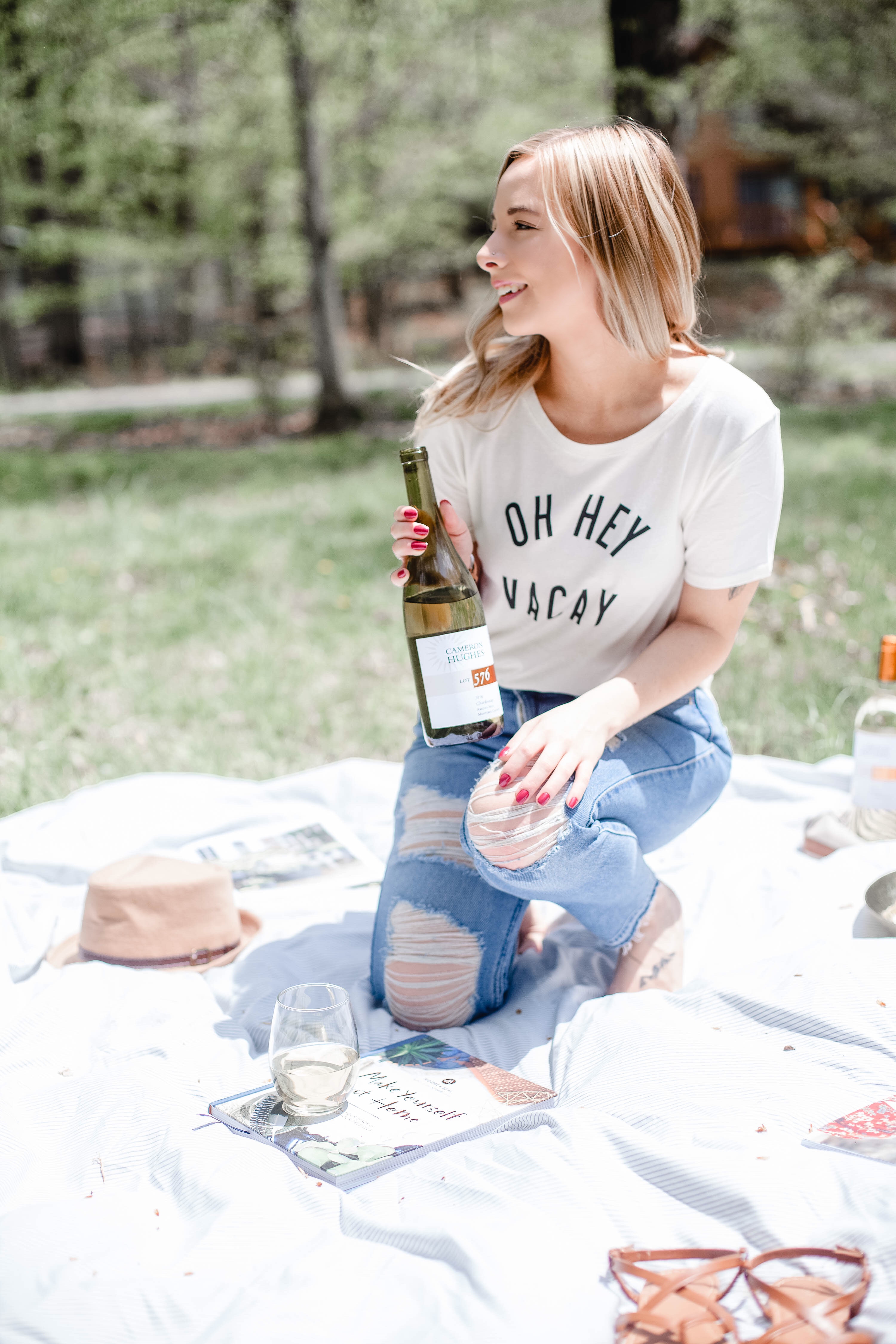 Woman holding a bottle of wine with Oh Hey Vacay T-Shirt on