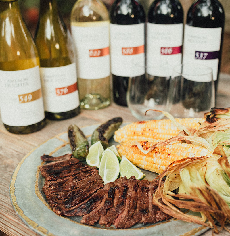A collection of Cameron Hughes wine bottles paired with steak and corn