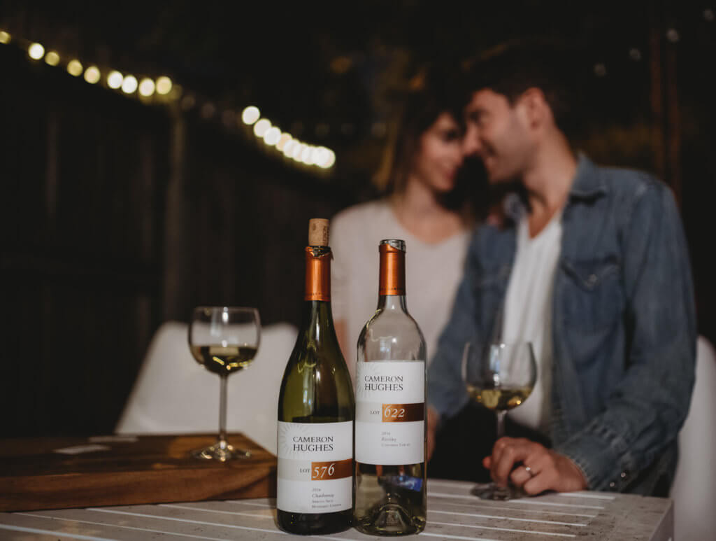A couple enjoys a romantic wine moment outdoors at night