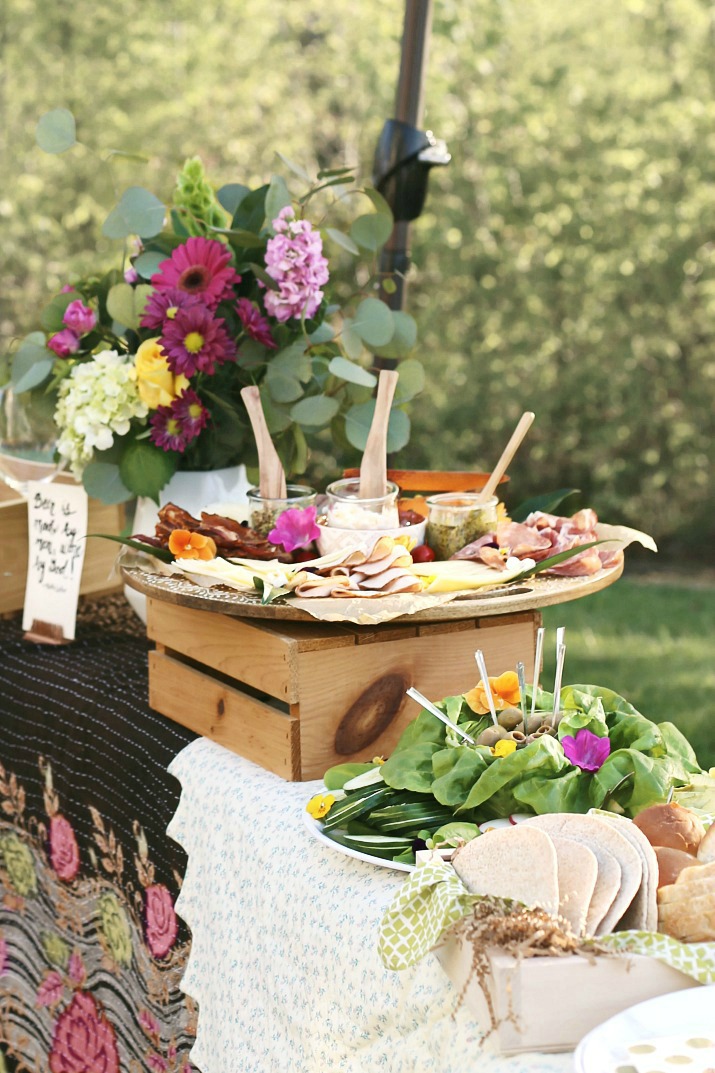DIY sandwich station beautifully arranged with fresh flowers outside