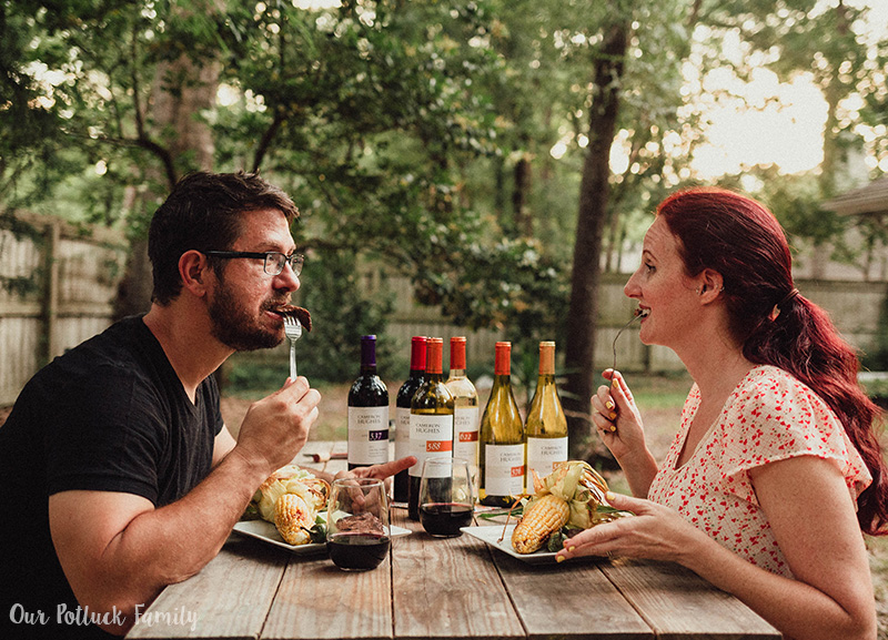 A couple enjoying steak dinner outside paired with wine