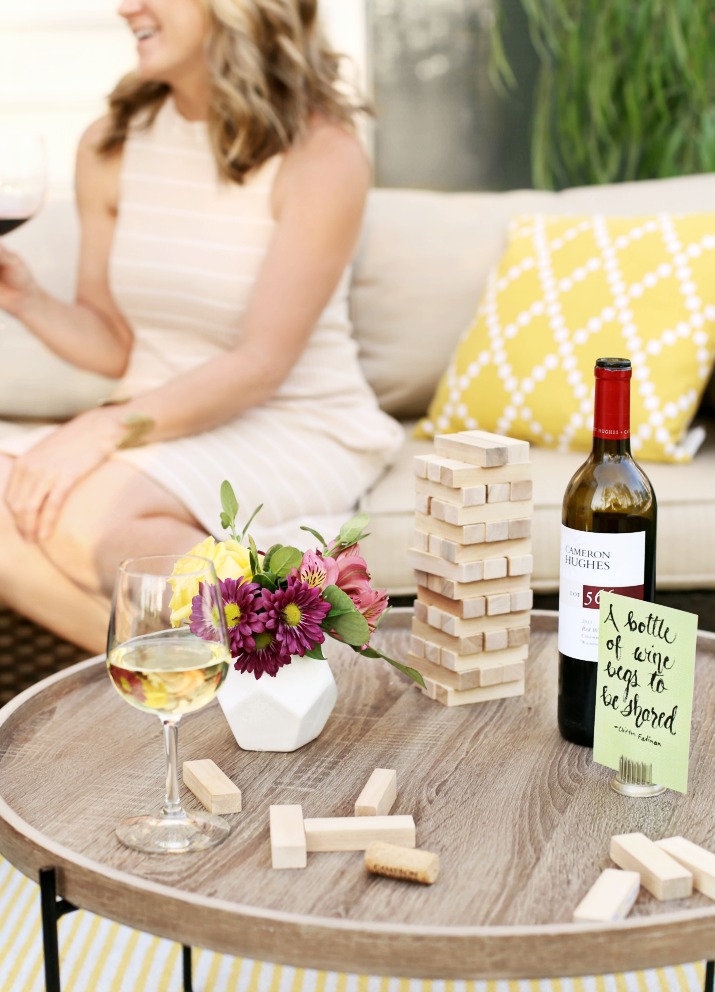 A bottle of Cameron Hughes wine on a table with jenga and fresh flowers
