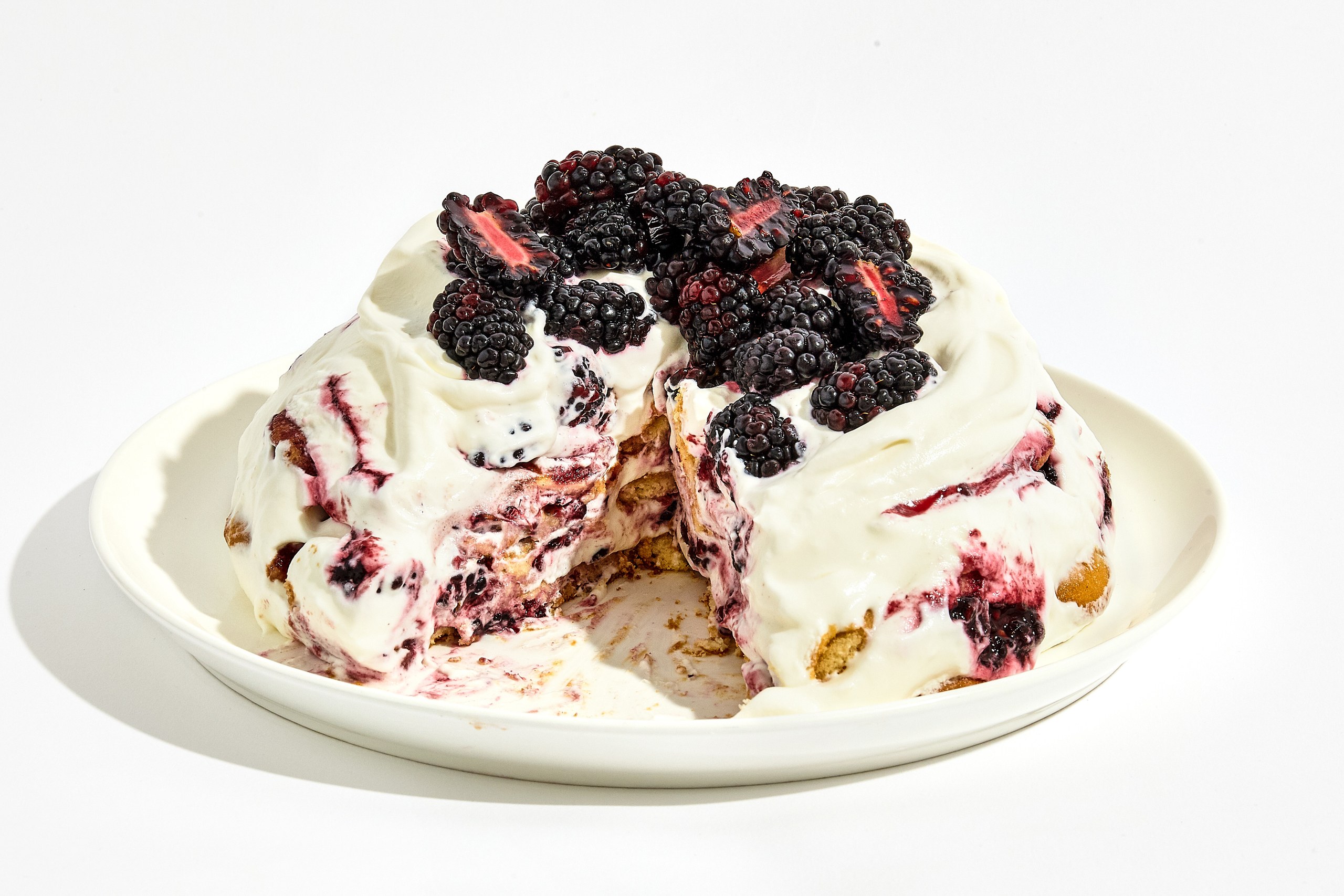 Blackberry icebox cake on a plate topped with fresh blackberries