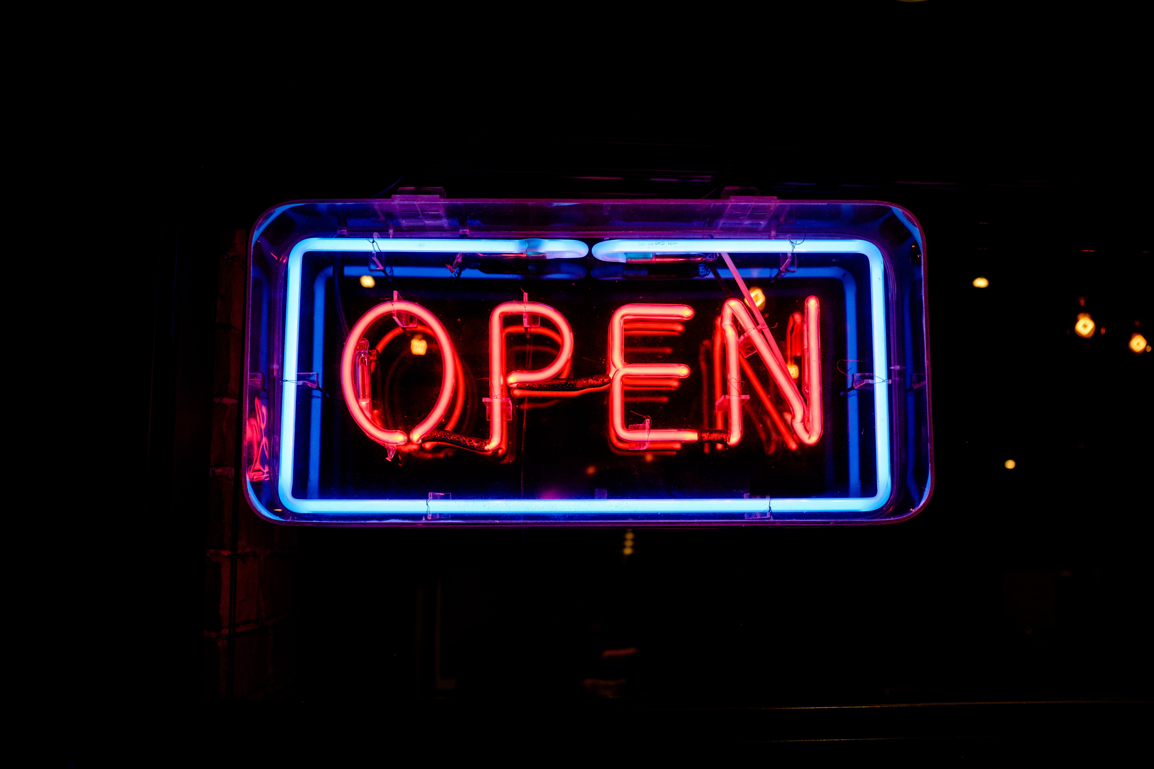 Neon sign that reads "Open" in red letters with a blue border