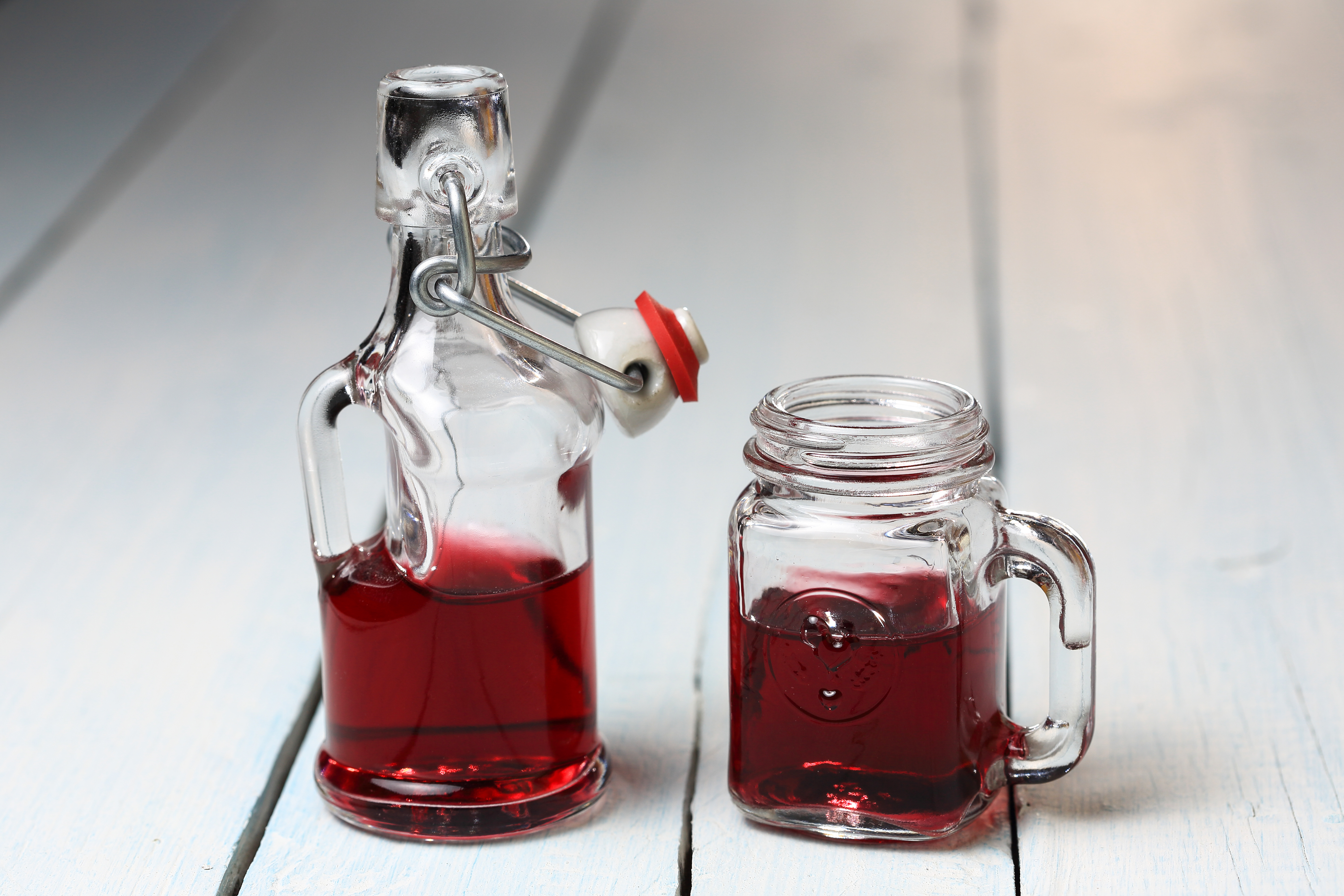 Red wine in a glass vessel and mug