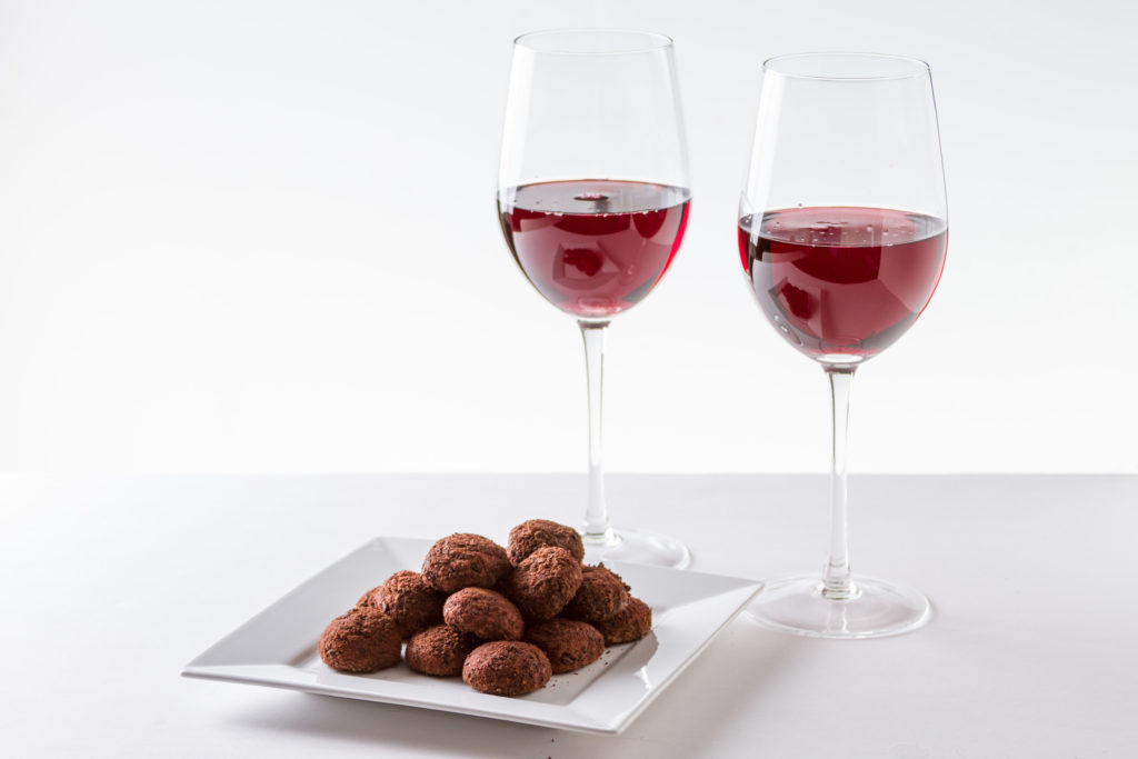 Two glasses of a light red wine paired with chocolates