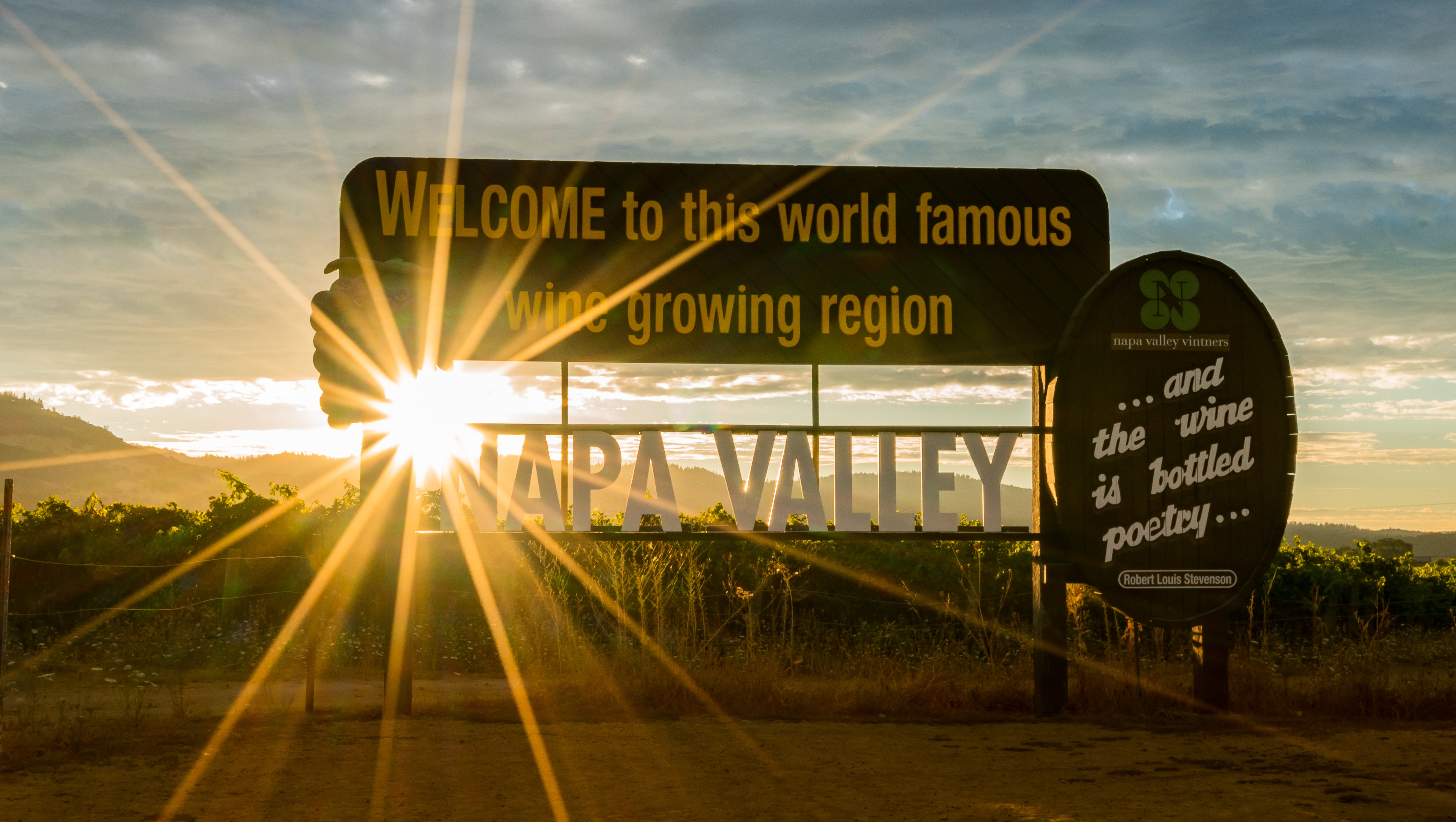 Sunset shines through a sign welcoming visitors to Napa Valley wine country