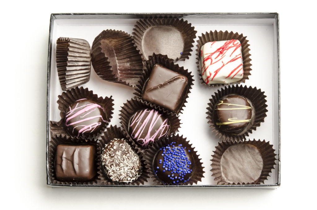 A half-eaten box of mixed chocolates perfect for wine pairing