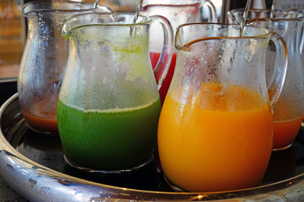 Glass pitchers of fresh juice for Mimosa production