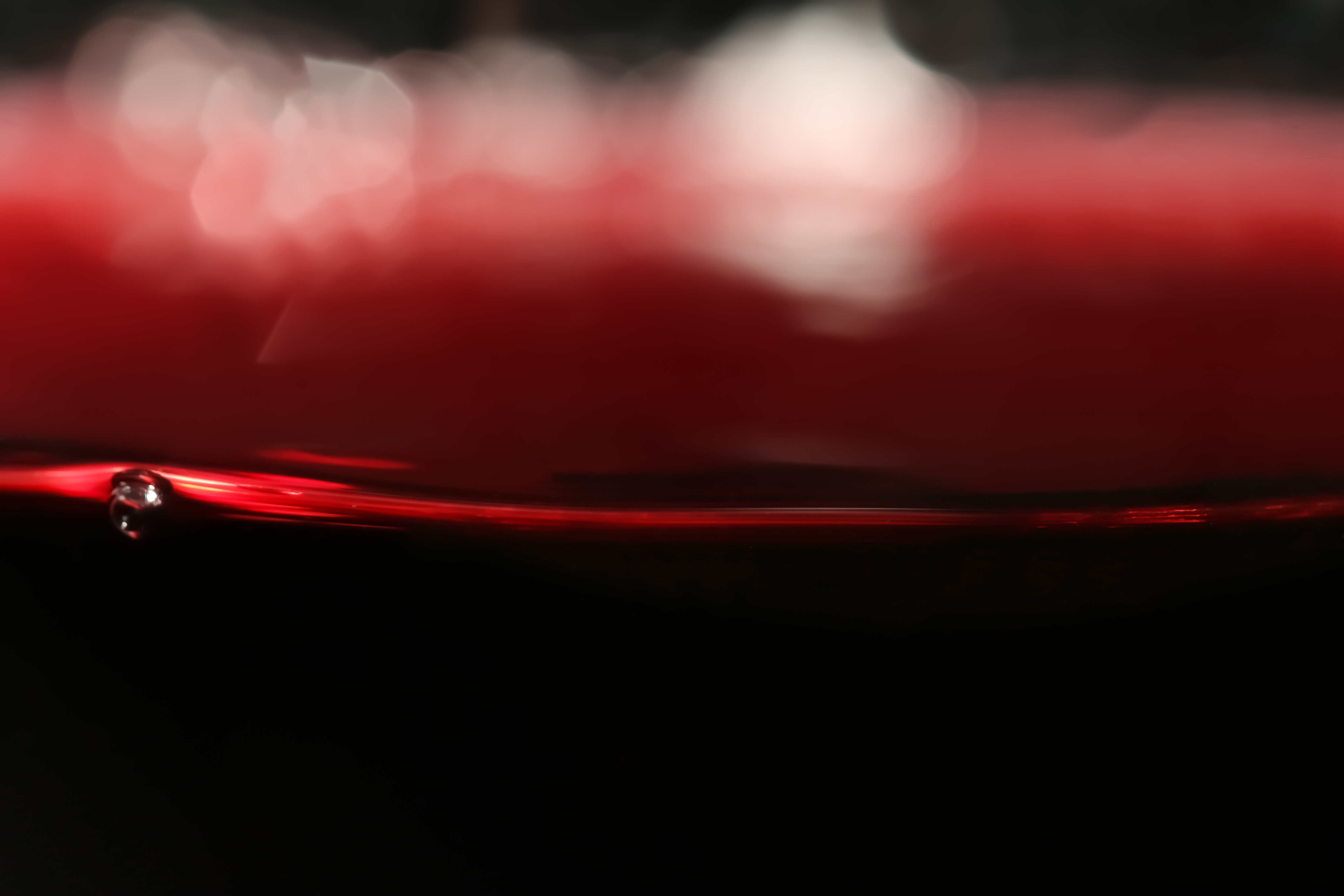 Delicious Merlot red wine in glass as background, closeup